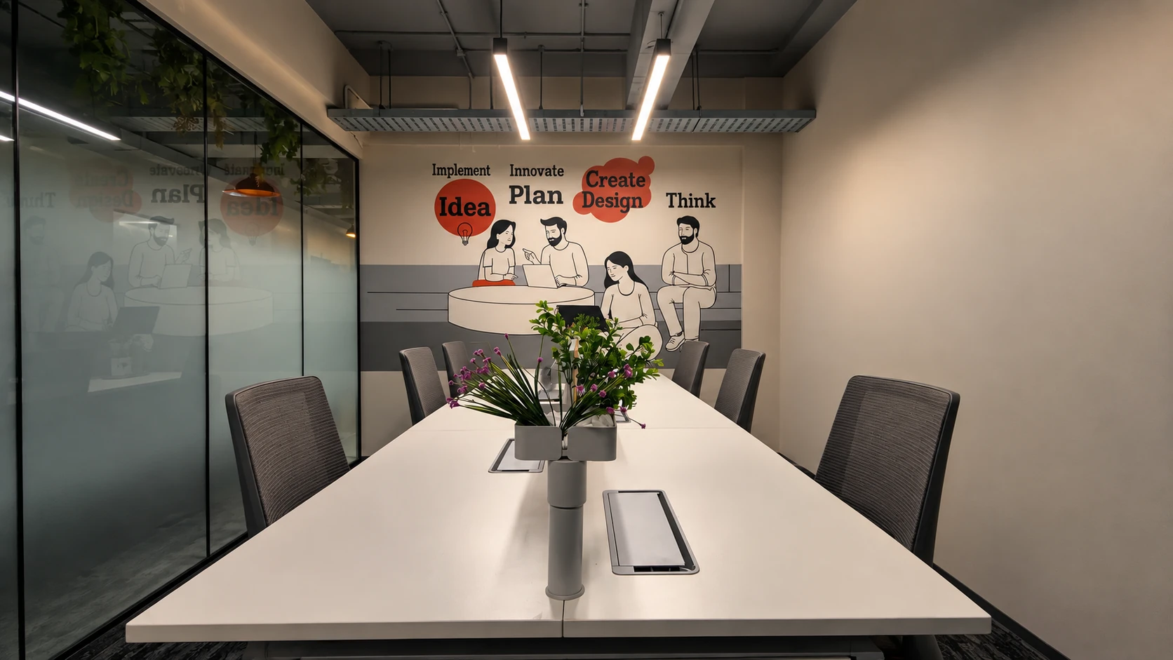 Private team room with white desks, grey chairs and a creative mural