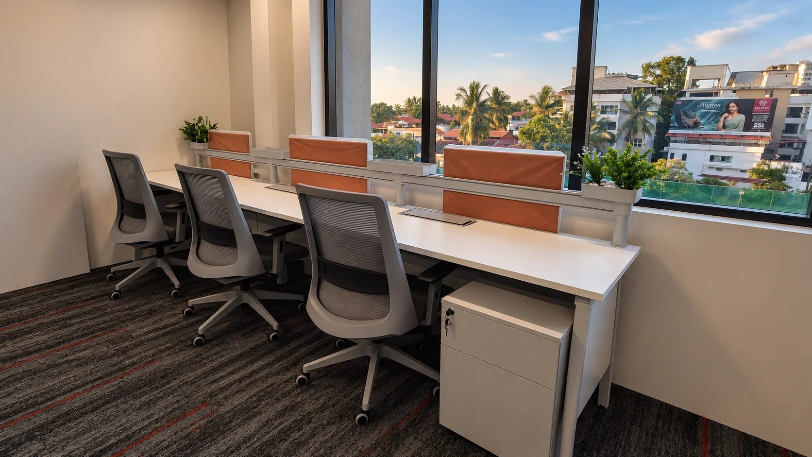 Sunlit desks, orange dividers and green planters at Bitpod Alake